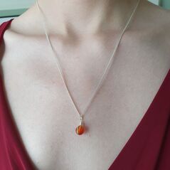 Small red agate sphere bound in a simple wire wrap onto silver chain. crystal is a vibrant orange/red colour