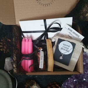 Love spell box containing pink candles, palo santo stick, jar of dried rose petals, a handmade rose quartz crystal necklace on dainty silver chain and an original ritual wrote by a  witch